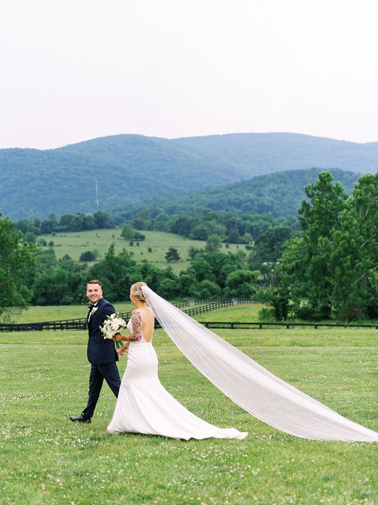 bride and groom walk across a green lawn at King Family Vineyards in Virginia. Photographed by Virginia wedding photographer Kim Branagan.