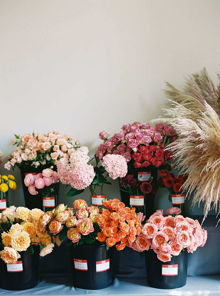 Carnations in shades of oranges, pinks, and reds in black pots at the Foraged Collective Floral Workshop in Charleston, SC