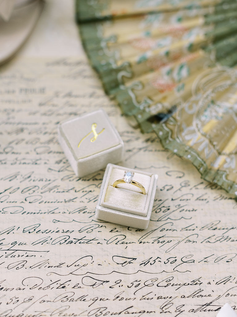 Close up shot of a bride's diamond engagement ring on a cursive, handwritten letter. Taken by D.C. wedding photographer Kim Branagan.