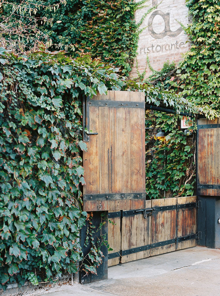 A wooden gate surrounded by vine covered walls at Aurora restaurant in Brooklyn, NY. Photographed by New York commercial photographer Kim Branagan.