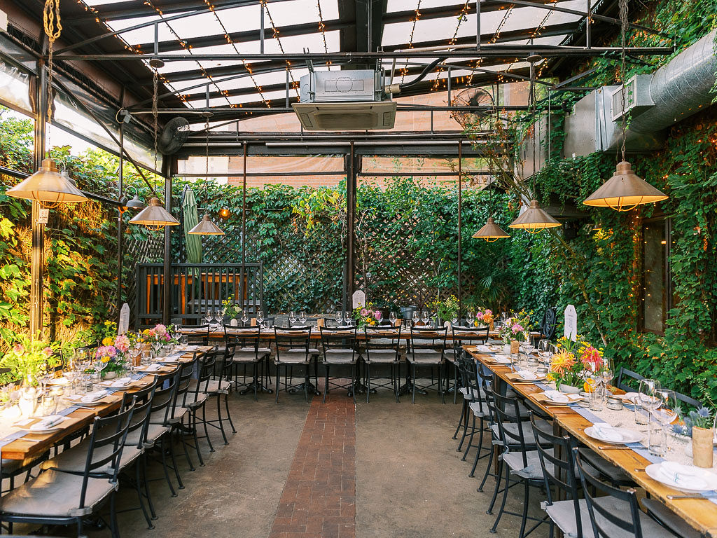 Outdoor garden area at Aurora restaurant in Williamsburg, Brooklyn set up with tables for a wedding reception
