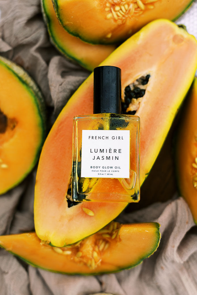 Close up shot of a small bottle of body oil on top of a papaya half. Photographed for Verde Lusso by East Coast branding and editorial photographer Kim Branagan.