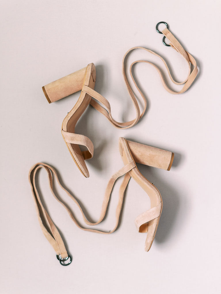 The bride's open-toed high heeled sandals on a plain white surface. Photographed by northern Virginia wedding photographer Kim Branagan