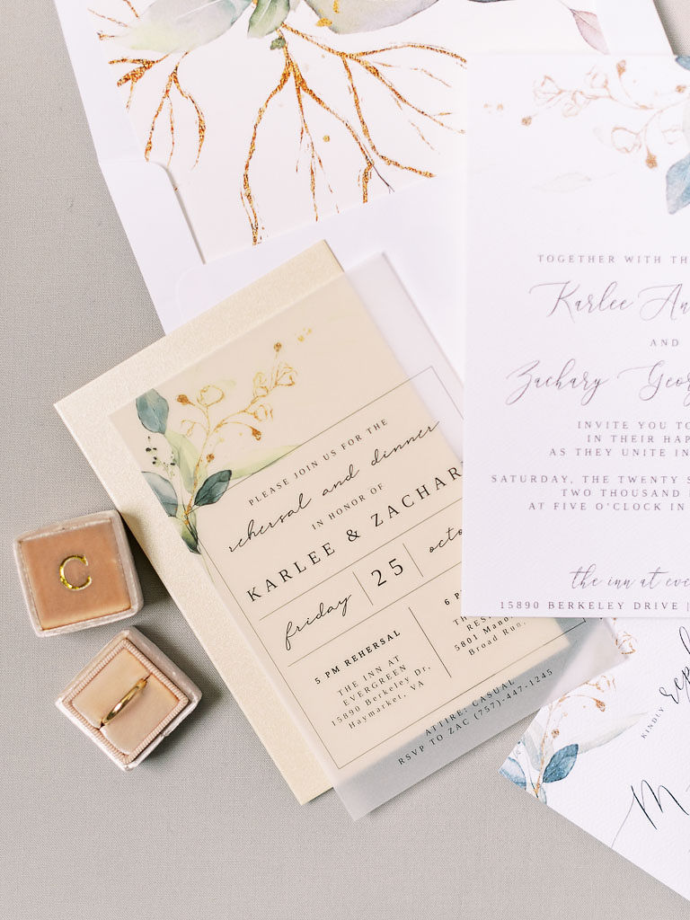 The couple's wedding invitation, save the date card, and wedding band