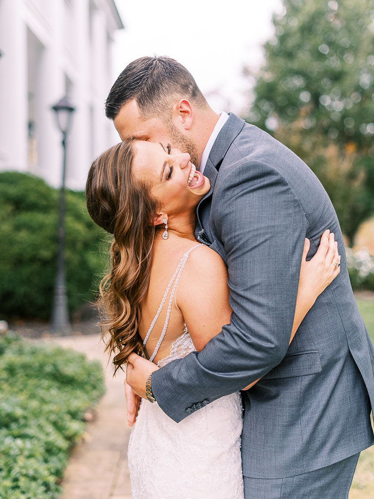 A bride and groom laugh and embrace on their wedding day. Photographed by Virginia wedding photographer Kim Branagan