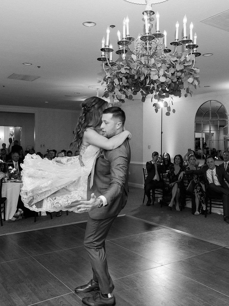 A groom twirls his bride through the air on the dancefloor at their wedding reception at Evergreen Country Club in Haymarket, Virginia.