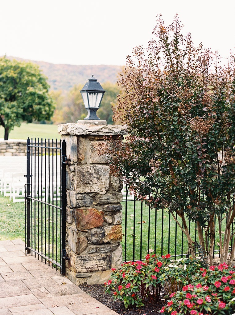 A decorative fence with a brick pillar and a lantern on top of the pillar at Evergreen Country Club in Haymarket, VA.