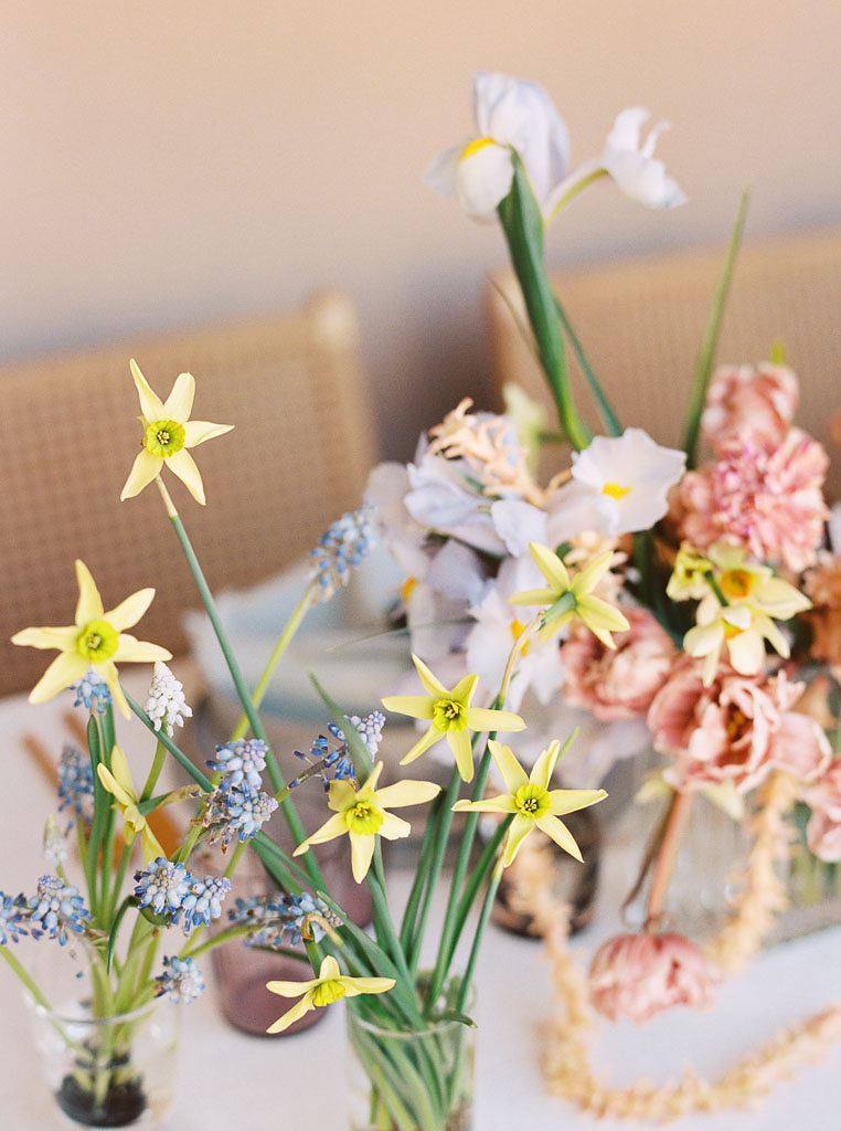 Close up shot of yellow, blue, white, and pink wildflowers arranaged in small bouquets on a table. Photographed by California editorial photographer Kim Branagan
