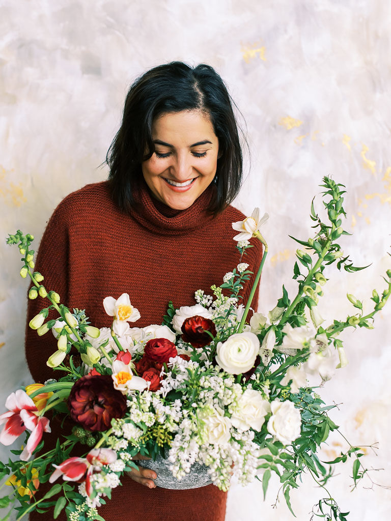 Amy of Amy Nicole Floral holds the floral centerpiece she designed as a demonstration at her floral workshop with Sweet Root Village