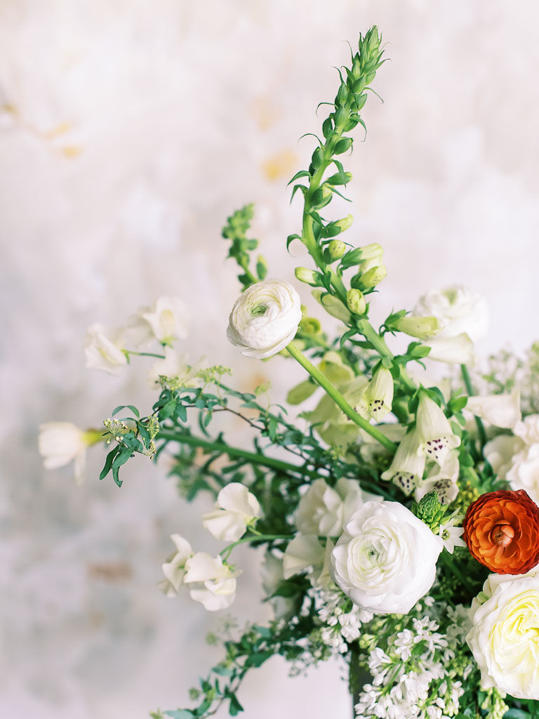 Close up view of white flowers and greenery against a marble backdrop