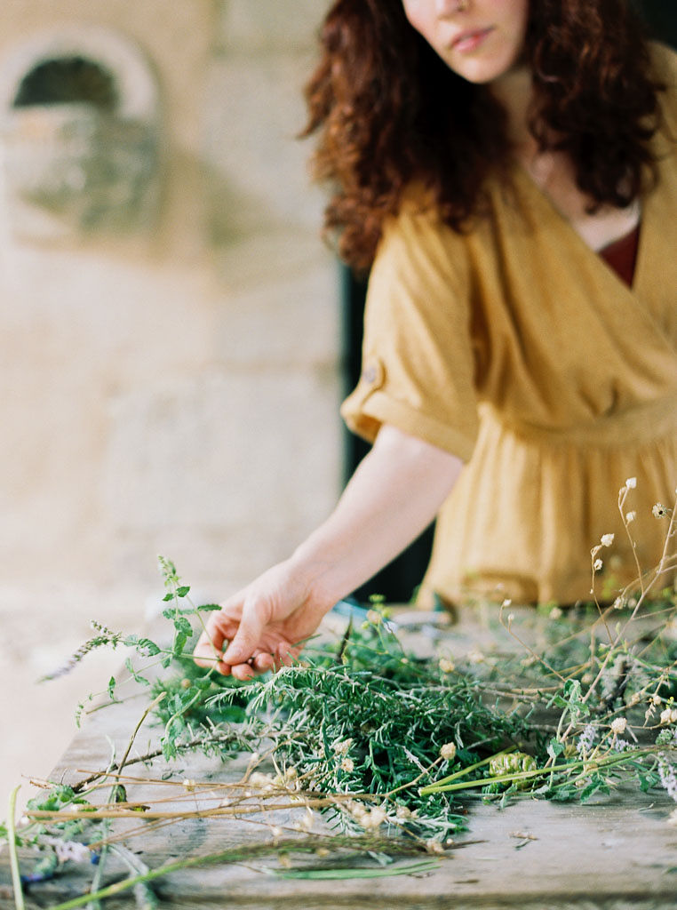 Closeup shot of a woman holding foliage she is going to add to her floral arrangement at the Clarity Retreat by Ponderosa & Thyme. Clarity Retreat - A Floral Workshop by Ponderosa & Thyme | Florence, Italy. Photographed by Florence brand and editorial photographer Kim Branagan.
