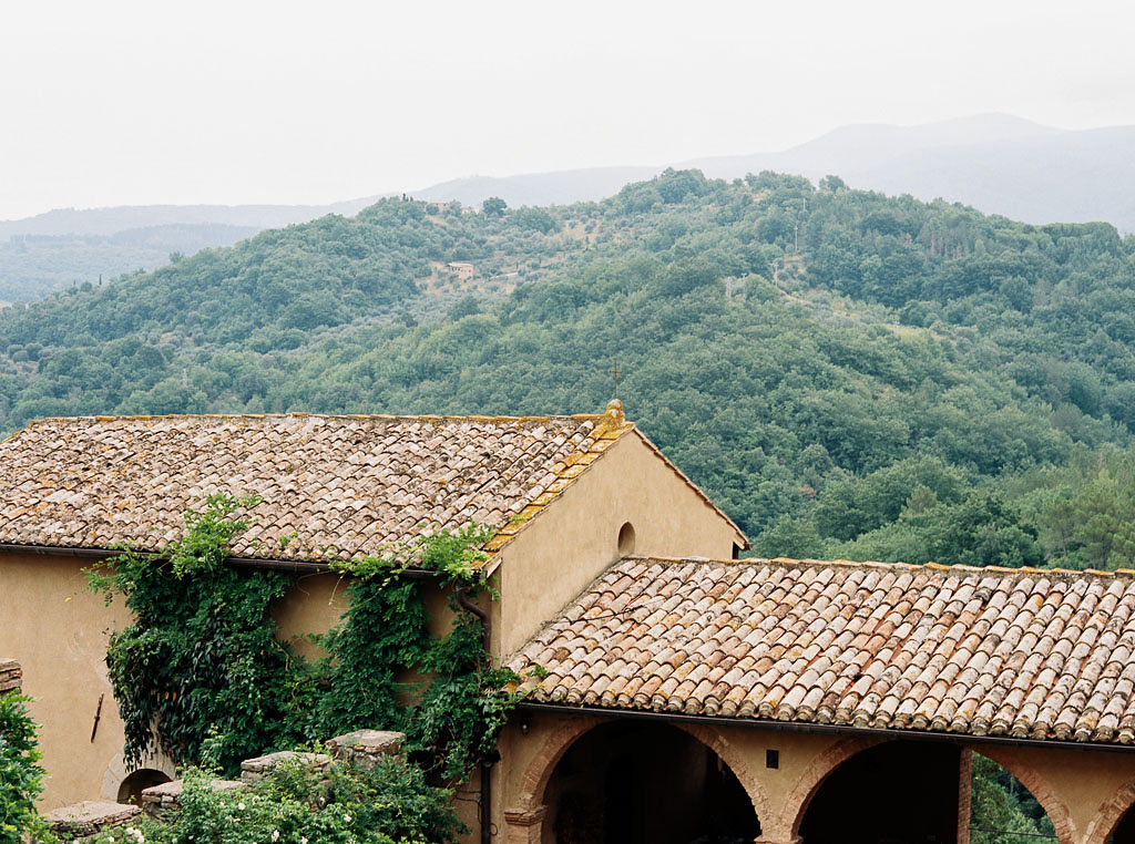 The shingles on a roof of an Italian villa with lush hills behind it. Clarity Retreat - A Floral Workshop by Ponderosa & Thyme | Florence, Italy. Photographed by Florence brand and editorial photographer Kim Branagan.
