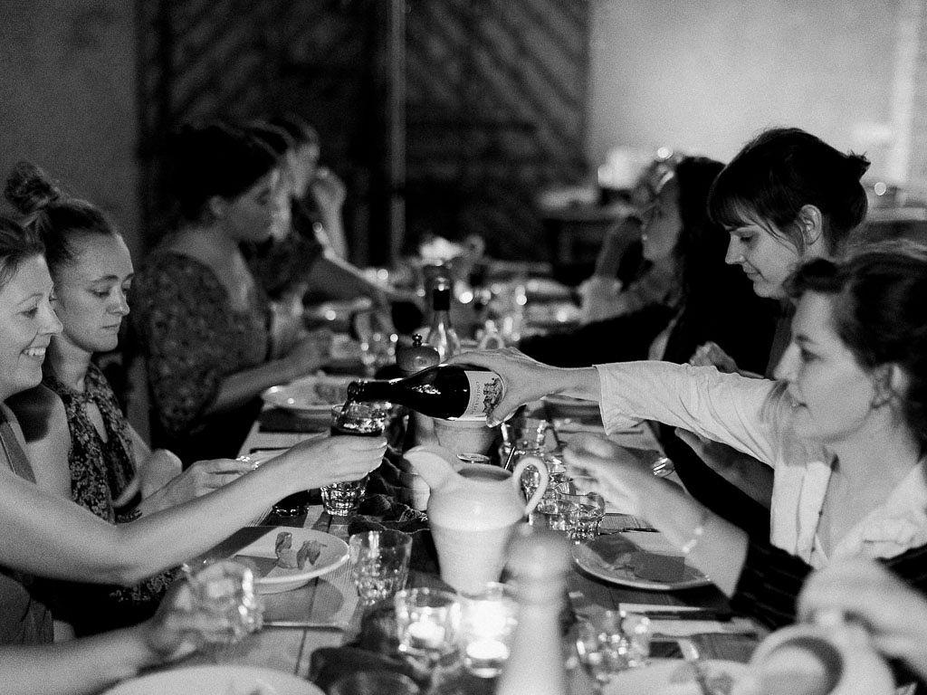 A long table of people enjoying a banquet meal. Clarity Retreat - A Floral Workshop by Ponderosa & Thyme | Florence, Italy. Photographed by Florence brand and editorial photographer Kim Branagan.